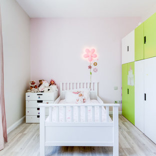 Cette photo montre une chambre d'enfant de 1 à 3 ans tendance de taille moyenne avec un sol en bois clair et un mur multicolore.