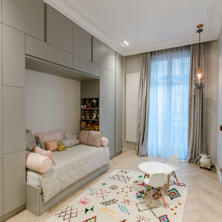 Réalisation d'une chambre d'enfant de 1 à 3 ans design avec un mur gris et un sol en bois clair.