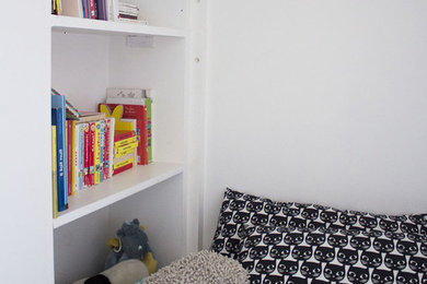Cette photo montre une petite chambre d'enfant de 4 à 10 ans moderne avec un mur blanc et parquet clair.