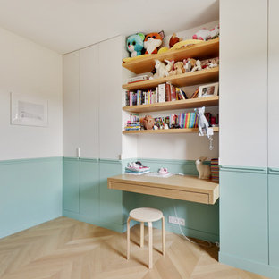 Cette photo montre une chambre de fille de 4 à 10 ans scandinave avec un bureau, un mur multicolore, un sol en bois clair et un sol beige.