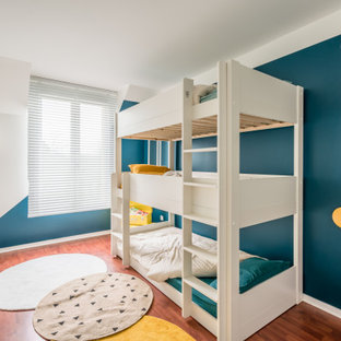 Cette photo montre une chambre d'enfant tendance de taille moyenne avec un mur bleu, un sol en bois brun et un sol marron.