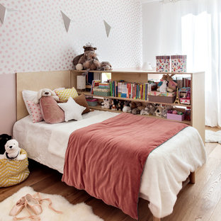 Idées déco pour une chambre d'enfant contemporaine avec un mur rose, un sol en bois brun et un sol marron.