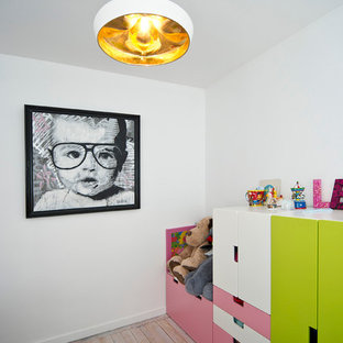 Aménagement d'une chambre d'enfant de 1 à 3 ans contemporaine de taille moyenne avec un mur blanc et un sol en bois clair.