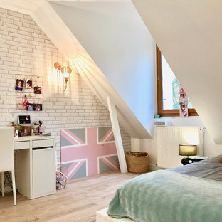 Cette photo montre une chambre tendance de taille moyenne avec un mur blanc, sol en stratifié et du papier peint.