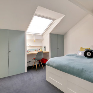 Idée de décoration pour une grand chambre d'enfant design avec un mur blanc, moquette, un sol bleu et un plafond en poutres apparentes.