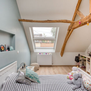 Réalisation d'une chambre d'enfant minimaliste avec un mur blanc, un sol en bois clair et un sol beige.