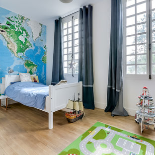Inspiration pour une grand chambre d'enfant de 4 à 10 ans traditionnelle avec un mur blanc et un sol en bois clair.