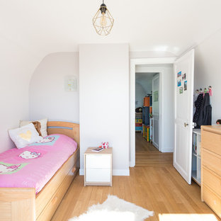 Idées déco pour une chambre d'enfant de 4 à 10 ans contemporaine avec un mur blanc, un sol en bois clair et un sol beige.