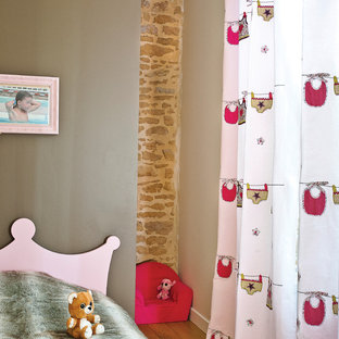 Idées déco pour une chambre d'enfant de 4 à 10 ans contemporaine de taille moyenne avec un sol en bois brun et un mur multicolore.