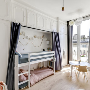 Idée de décoration pour une chambre d'enfant de 4 à 10 ans nordique de taille moyenne avec un mur blanc, un sol en bois clair et un sol beige.
