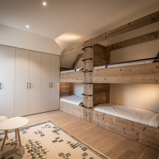 Inspiration för ett mellanstort rustikt könsneutralt barnrum kombinerat med sovrum och för 4-10-åringar, med beige väggar och ljust trägolv