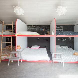 Idée de décoration pour une chambre d'enfant de 4 à 10 ans design de taille moyenne avec béton au sol et un mur multicolore.