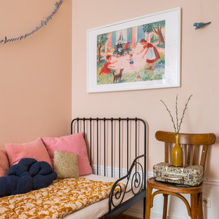 Idée de décoration pour une chambre d'enfant de 4 à 10 ans nordique de taille moyenne avec un mur rose et un sol en bois brun.