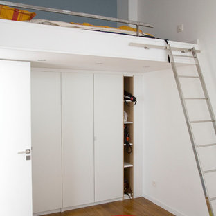 Cette image montre une chambre d'enfant urbaine de taille moyenne avec un sol en bois brun et un mur multicolore.
