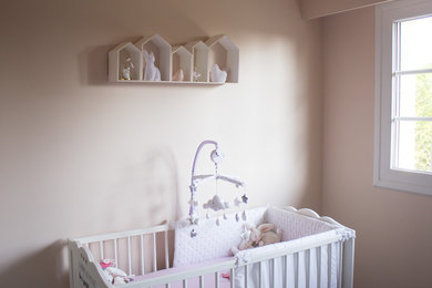 Inspiration for a medium sized vintage nursery for girls in Other with pink walls, laminate floors and grey floors.