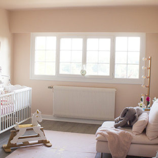 Idee per una cameretta per neonata shabby-chic style di medie dimensioni con pareti rosa, pavimento in laminato e pavimento grigio