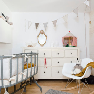 Inspiration pour une chambre de bébé neutre nordique de taille moyenne avec un mur blanc, un sol en bois clair et un sol beige.