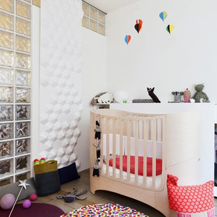 Inspiration pour une chambre de bébé neutre design de taille moyenne avec un mur blanc et un sol en bois clair.