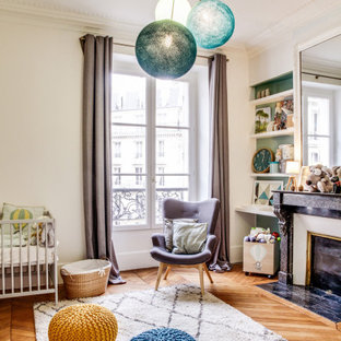 Inspiration pour une chambre de bébé neutre nordique de taille moyenne avec un mur blanc, un sol marron et un sol en bois clair.