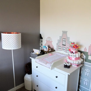 Esempio di una piccola cameretta per neonata shabby-chic style con pareti grigie, pavimento in laminato e pavimento marrone
