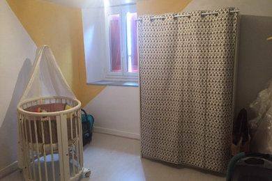 Ejemplo de habitación de bebé neutra actual de tamaño medio con paredes blancas y suelo laminado
