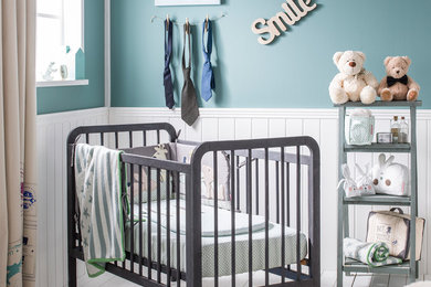 Imagen de habitación de bebé niño contemporánea de tamaño medio con paredes azules y suelo de madera pintada