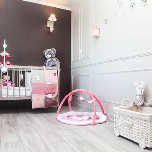 Esempio di una cameretta per neonata stile shabby di medie dimensioni con pareti beige, pavimento in laminato e pavimento beige