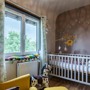 Cette image montre une chambre de bébé fille bohème avec un mur gris.