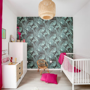 Exemple d'une chambre de bébé fille exotique avec un mur multicolore, un sol en bois clair et un sol beige.