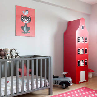 Exemple d'une chambre de bébé neutre scandinave de taille moyenne avec un mur gris, un sol en bois clair et un sol beige.