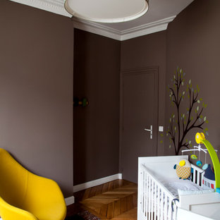 Inspiration pour une chambre de bébé neutre design de taille moyenne avec un mur marron et un sol en bois brun.