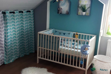 Idées déco pour une petite chambre de bébé garçon scandinave avec un mur gris et un sol en bois brun.