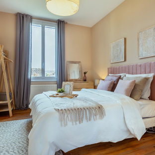 Cette photo montre une chambre parentale méditerranéenne de taille moyenne avec un mur jaune, un sol en bois clair, aucune cheminée et un sol marron.