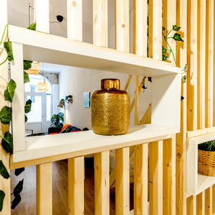 Ejemplo de dormitorio tipo loft, contemporáneo, pequeño, con paredes blancas y suelo de madera clara