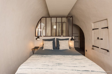 Aménagement d'une chambre éclectique avec un mur blanc, sol en béton ciré, un sol gris et verrière.
