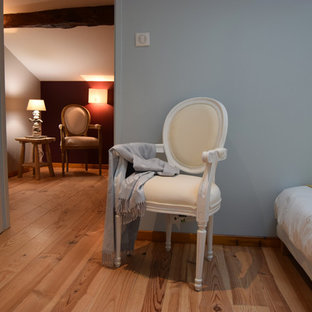 Idee per una camera da letto country con pareti rosse e parquet chiaro