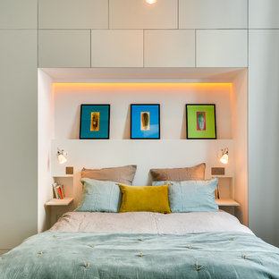 Cette photo montre une chambre scandinave avec un mur gris et un sol en bois clair.