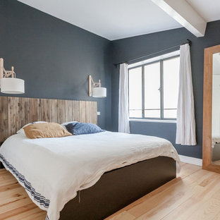 Esempio di una grande camera matrimoniale costiera con pareti blu, parquet chiaro e nessun camino