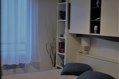 Foto de dormitorio principal actual de tamaño medio con paredes blancas y suelo laminado
