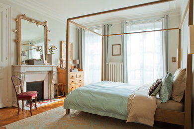 Aménagement d'une grande chambre parentale classique avec un mur gris, une cheminée standard, parquet foncé, un manteau de cheminée en pierre et un sol marron.