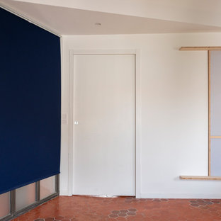 Imagen de dormitorio principal, contemporáneo, grande, con paredes blancas, suelo de baldosas de terracota y suelo rosa