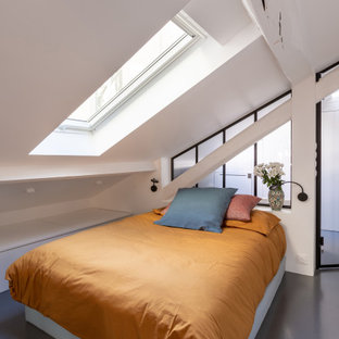 Ejemplo de dormitorio tipo loft, industrial, pequeño, con paredes blancas, suelo de cemento y suelo gris