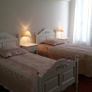 Ejemplo de habitación de invitados de estilo de casa de campo, grande, sin chimenea, con paredes beige y suelo de baldosas de terracota