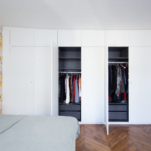 Cette photo montre une chambre tendance avec un sol en bois brun, un sol marron et un mur jaune.