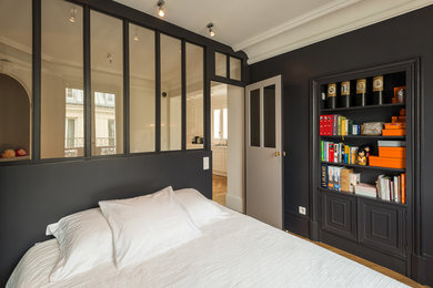 Exemple d'une chambre parentale tendance de taille moyenne avec un mur noir, un sol en bois brun et un sol marron.