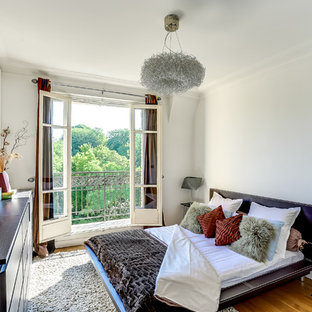 Exemple d'une chambre tendance avec un mur blanc, un sol en bois brun et aucune cheminée.