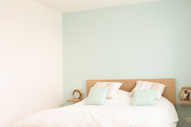 Foto de dormitorio principal y blanco y madera escandinavo de tamaño medio con suelo de madera clara y paredes azules