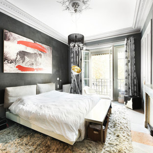 Cette image montre une chambre bohème avec un mur noir, une cheminée standard et un sol gris.