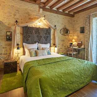 Idée de décoration pour une chambre champêtre avec un mur beige, un sol en bois brun et un sol marron.