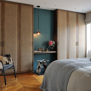 Idée de décoration pour une chambre design de taille moyenne avec un mur blanc, un sol en bois brun et un sol marron.